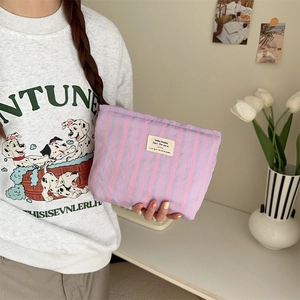 Close-up of pink striped quilted canvas makeup bag with woven label detail