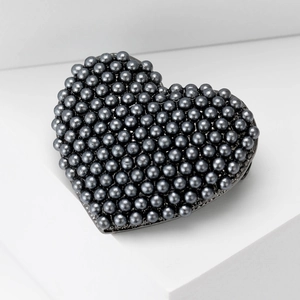 Detailed close-up of heart-shaped brooch with dark grey pearls and dark metal base