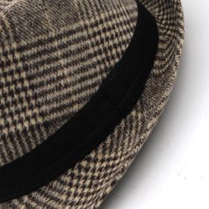 Close-up of wool fedora featuring classic houndstooth pattern and black ribbon detail