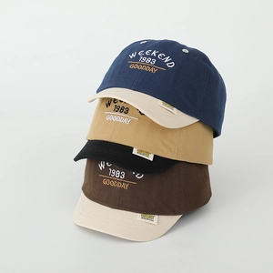 Detail view of cotton baseball caps with embroidered WEEKEND 1983 letters in four colors