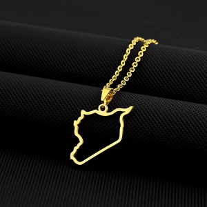Macro shot of gold Syria map pendant with cutout design on textured black surface