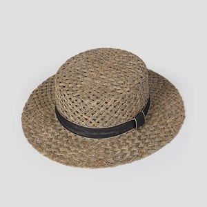 Top-down view of a classic woven straw flat top boater hat with a black ribbon band detail