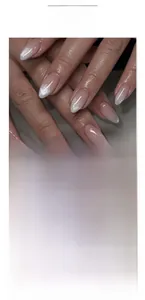 Close-up of almond-shaped nude pink press-on nails with silver cat-eye glitter gradient