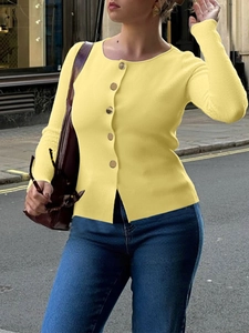 Street style view of a women's yellow knit cardigan with gold buttons and long sleeves