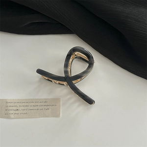 Détail de la pince à cheveux torsadée écaille noir et gris avec ressort en métal doré