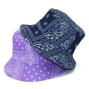 Detail of purple and navy paisley pattern reversible cotton bucket hats for sun protection