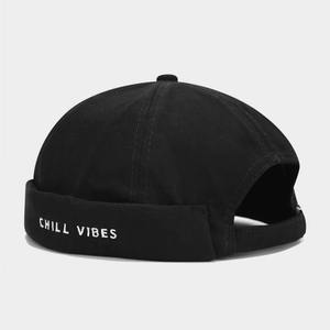 Detail view of cotton docker cap with white Chill Vibes embroidery on black fabric