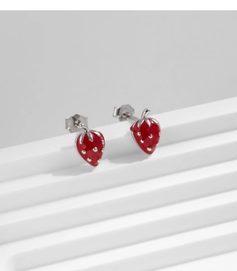 Macro shot of 925 silver strawberry stud earrings with red enamel and leaf details