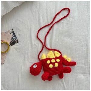 Detail of red handmade knit dinosaur crossbody bag for kids with yellow spines