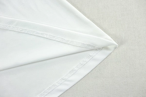 Macro shot of double-stitch edge detailing on the white ruched dress hemline