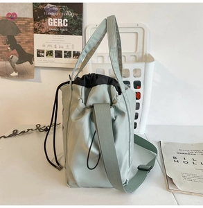 Detail of mint green nylon drawstring bag with adjustable strap and dual handles