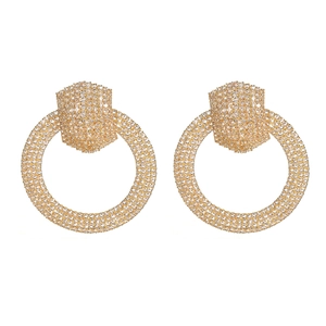 Exaggerated golden geometric round earrings with sparkling rhinestones on white background