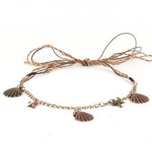 Macro shot of boho braided rope accessory with bronze alloy shell and starfish pendants