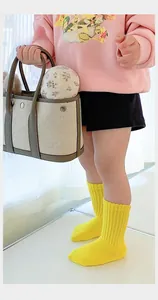 Close-up of bright lemon yellow ribbed cotton mid-calf socks for children on model