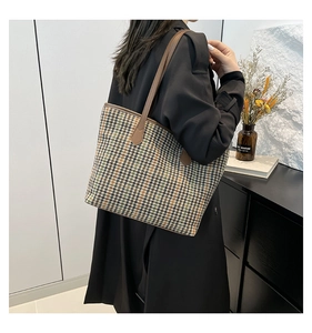 Close-up of retro houndstooth tote bag with brown leather straps for autumn style