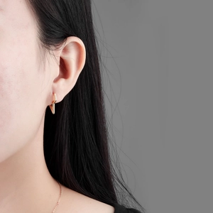 Minimalist gold lightning bolt hoop earrings on female model with a sleek geometric design