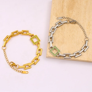Detail of 18K gold plated bracelet featuring green crystal inlay and lobster clasp closure