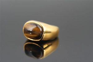 Detail of gold tiger eye stone ring featuring oval cabochon and polished finish