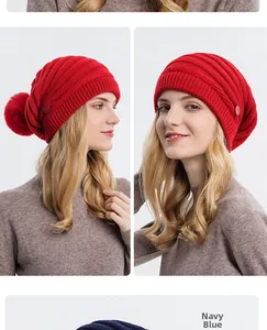 Détail du bonnet en tricot bleu marine avec pompon en fourrure et bouton sur le côté