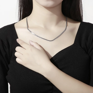 Close-up of a stylish silver stainless steel flat snake chain necklace on model neck