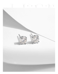 Macro shot of 1 carat round moissanite earrings in classic silver four-prong setting
