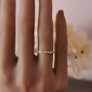 Primo piano di un sottile anello dorato con zirconi bianchi indossato per un look alla moda
