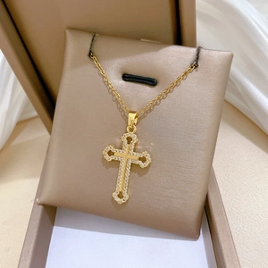 Detailed close-up of a gold titanium steel hollow cross necklace with sparkling crystals