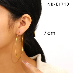 Detailed view of 7cm large gold stainless steel C-shaped hoop earrings on female model