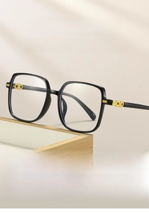 Detail view of large square black frame glasses with premium gold metal hinge accents