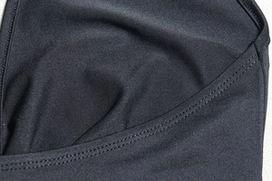 Detailed view of black elastic dress fabric with reinforced double-needle stitching seams