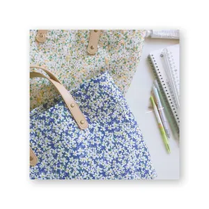 Detailed top view of floral canvas tote bags with leather handles and stationery items