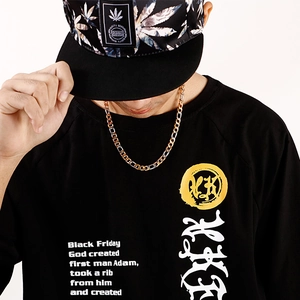 Detail of two-tone gold and silver Cuban link necklace on a model wearing a black t-shirt