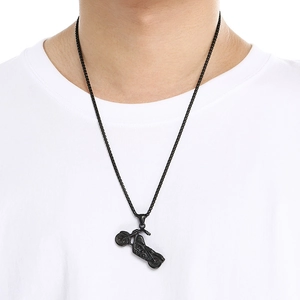 Dettaglio della collana con ciondolo moto punk nera indossata su t-shirt bianca