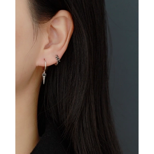 Close-up of geometric S925 sterling silver hoop earrings with black zircon drop on a model