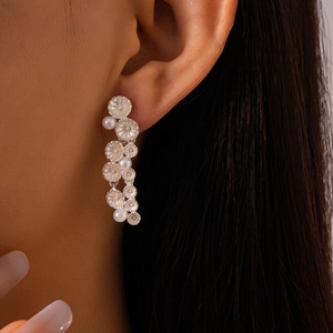 Detailed close-up of a silver flower tassel earring with pearls on a model wearing it