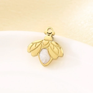 Macro shot of gold firefly pendant with pearl inlay detail for DIY jewelry making