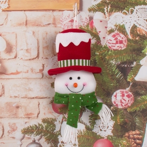 Christmas snowman plush ornament with red hat and green scarf hanging on a festive tree