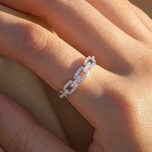 Detailed close-up of a silver chain ring with pave-set zircons worn on a finger