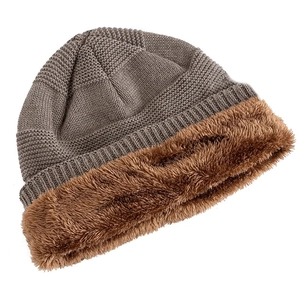 Detail of winter knit hat featuring dark gray ribbed texture and brown faux fur lining