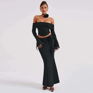 Detail of black off-shoulder long sleeve top and maxi skirt with 3D floral accents