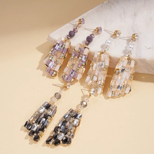 Detail of bohemian square glass drop earrings in purple white and black with gold accents