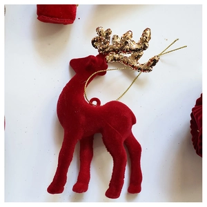 Close-up of red flocked reindeer ornament with golden glitter antlers and hanging gold cord