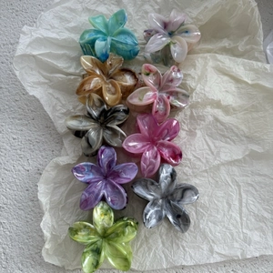 Floral marble hair claw clips in various colors arranged on white textured paper