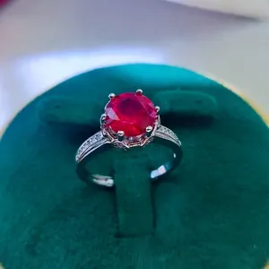 Detail of 2 carat red ruby ring with six-prong setting in a green velvet jewelry box