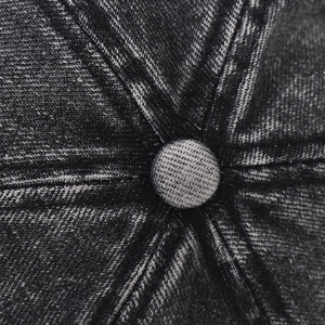 Macro close-up of the vintage washed denim fabric and top button on the baseball cap