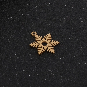 Élégant pendentif flocon de neige en acier inoxydable doré sur fond noir texturé