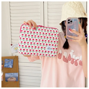 Quilted laptop sleeve with red tulip print and a Hello Everything Good Luck woven label