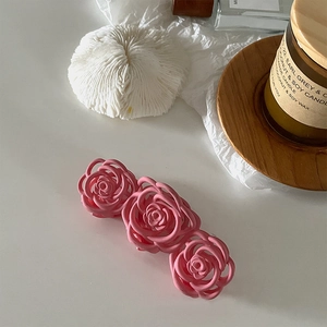 Gros plan sur la pince à cheveux rose mat en forme de rose dans un style romantique français