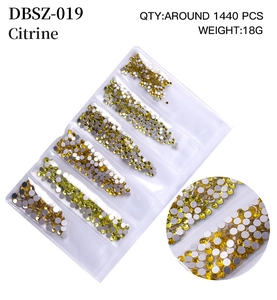 Macro detail of citrine flatback rhinestones for nail art in transparent organizer tray