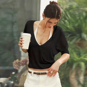 Detail of a chic black deep V-neck short sleeve top with a white halter neck inner layer